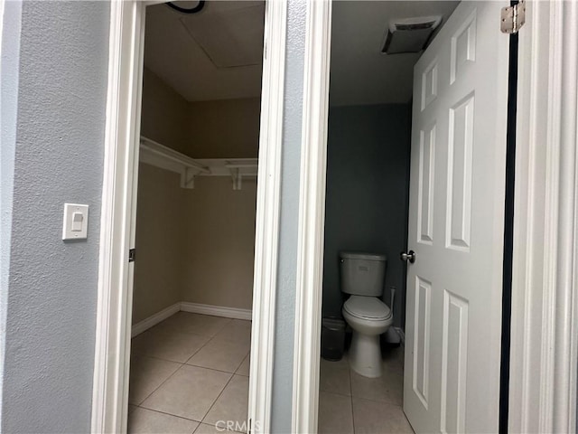 16193 Space Dr, Moreno Valley, CA 92551 - bathroom with tile patterned flooring, toilet, a walk in closet, and baseboards