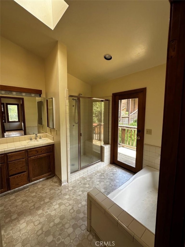 50771 Woodside Ln, Oakhurst, CA 93644 - bathroom featuring a skylight, vaulted ceiling, a stall shower, vanity, and tile patterned floors
