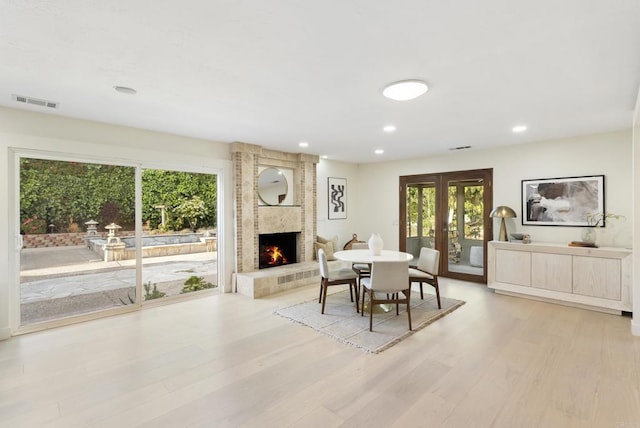 233233A Cole Ranch Rd, Encinitas, CA 92024 - dining space with a brick fireplace, light wood-style floors, recessed lighting, and french doors