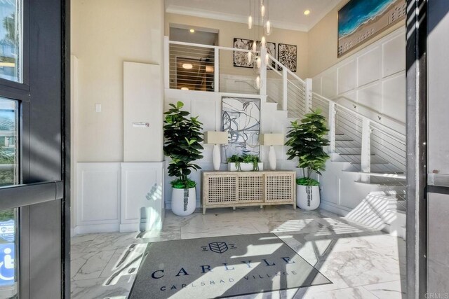 800 Grand Ave Unit 205, Carlsbad, CA 92008 - entryway featuring marble tiled floors, crown molding, a chandelier, and stairs