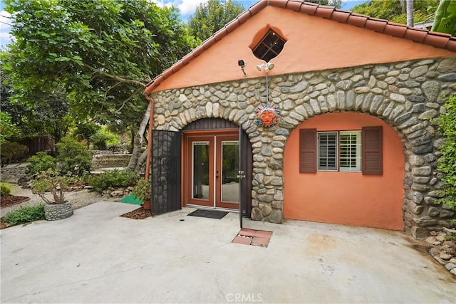 11022 Fruitland Dr, Studio City, CA 91604 - view of exterior entry featuring stone siding, french doors, a patio area, and stucco siding