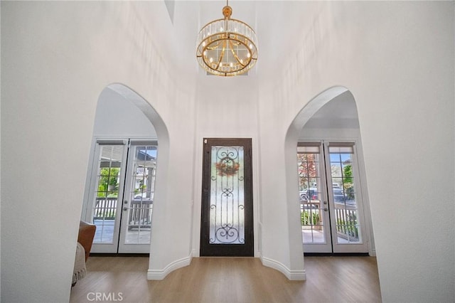 25422 Magnolia Ln, Stevenson Ranch, CA 91381 - entrance foyer featuring french doors, wood finished floors, a high ceiling, arched walkways, and a chandelier