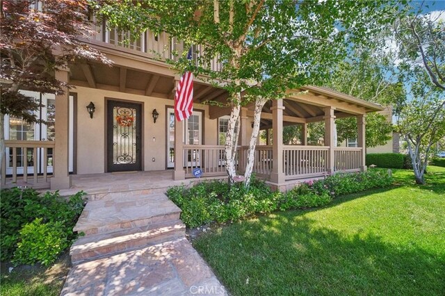 25422 Magnolia Ln, Stevenson Ranch, CA 91381 - doorway to property featuring a porch, stucco siding, and a lawn