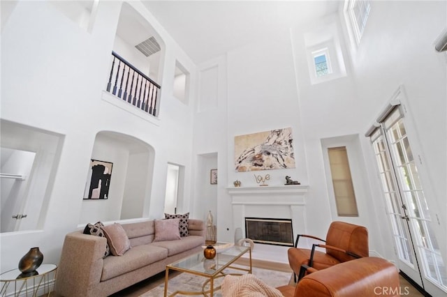 25422 Magnolia Ln, Stevenson Ranch, CA 91381 - living area featuring a towering ceiling, healthy amount of natural light, arched walkways, and a glass covered fireplace