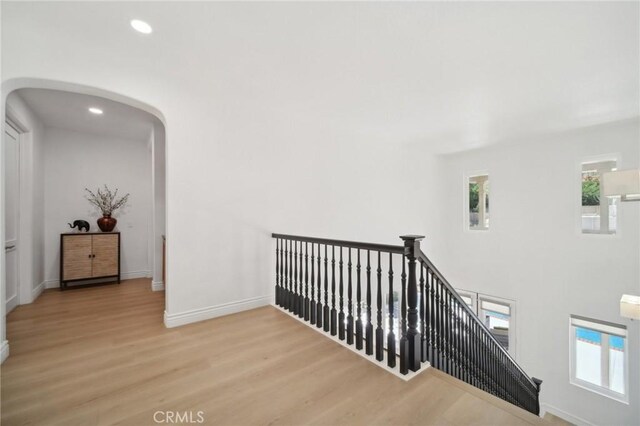 25422 Magnolia Ln, Stevenson Ranch, CA 91381 - hallway with an upstairs landing, arched walkways, wood finished floors, baseboards, and recessed lighting
