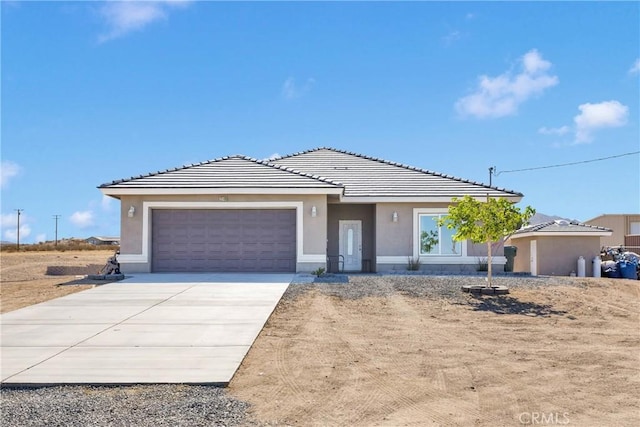 22489 Sweet Pea Rd, Oro Grande, CA 92368 - view of front of home featuring an attached garage, driveway, a tile roof, and stucco siding