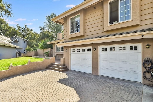 3738 Danmont Ct, Newbury Park, CA 91320 - view of side of property featuring an attached garage, decorative driveway, a yard, and stucco siding