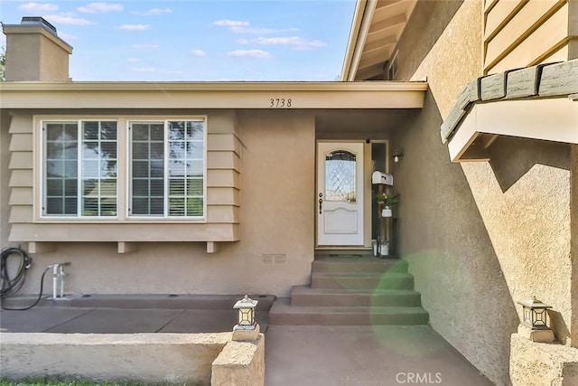 3738 Danmont Ct, Newbury Park, CA 91320 - doorway to property featuring stucco siding and a chimney