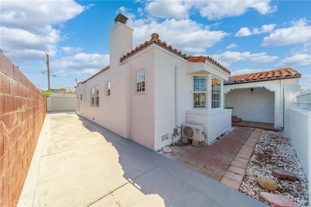 3825 Welland Ave, Los Angeles, CA 90008 - view of property exterior with a chimney, a cooling unit, a tiled roof, a fenced backyard, and a patio