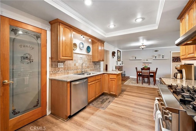 12713 16th St, Chino, CA 91710 - kitchen featuring stainless steel appliances, a sink, a tray ceiling, light wood-style flooring, and ornamental molding