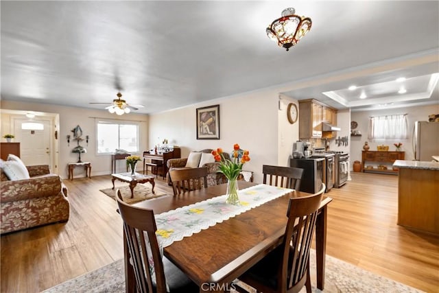 12713 16th St, Chino, CA 91710 - dining room with light wood-type flooring, a raised ceiling, ceiling fan, and crown molding