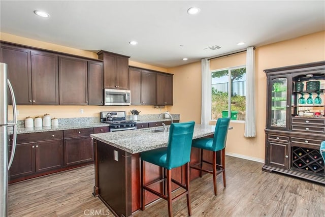 11294 Chappell Way, Beaumont, CA 92223 - kitchen featuring appliances with stainless steel finishes, a sink, light wood-style floors, light stone countertops, and recessed lighting