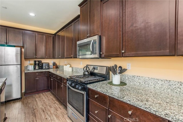 11294 Chappell Way, Beaumont, CA 92223 - kitchen featuring stainless steel appliances, light wood finished floors, light stone countertops, dark brown cabinetry, and recessed lighting