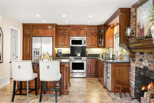 293 N Paseo De Juan, Anaheim Hills, CA 92807 - kitchen with appliances with stainless steel finishes, a sink, a breakfast bar, a kitchen island, and glass insert cabinets