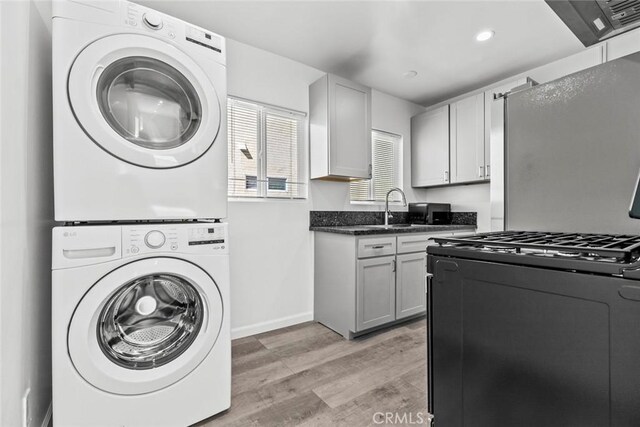 142 S Savannah St, Los Angeles, CA 90033 - laundry area with stacked washer and clothes dryer, light wood-type flooring, baseboards, and recessed lighting