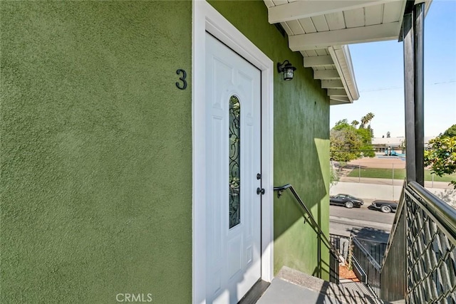 142 S Savannah St, Los Angeles, CA 90033 - doorway to property featuring stucco siding and a balcony