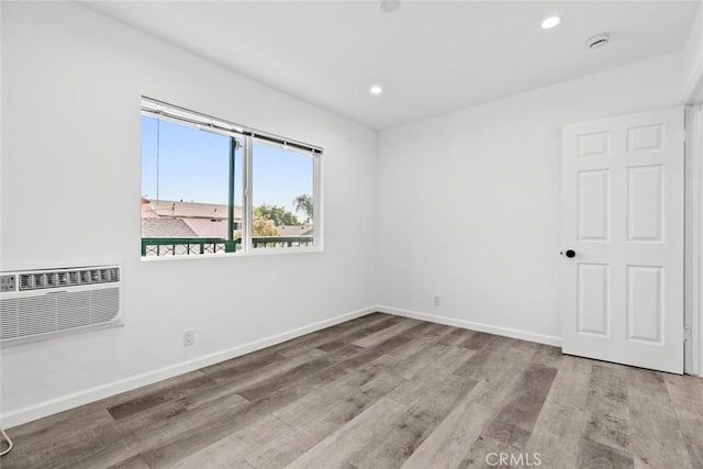 142 S Savannah St, Los Angeles, CA 90033 - spare room featuring wood finished floors, a wall mounted AC, baseboards, recessed lighting, and a smoke detector