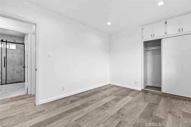 142 S Savannah St, Los Angeles, CA 90033 - unfurnished bedroom featuring recessed lighting, a closet, light wood-style floors, baseboards, and a barn door