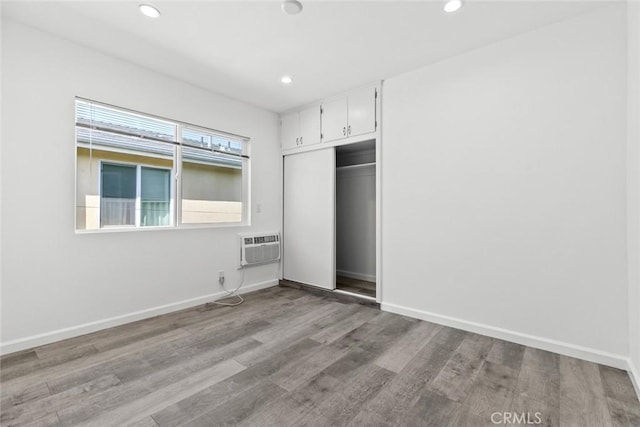 142 S Savannah St, Los Angeles, CA 90033 - unfurnished bedroom with a wall mounted AC, wood finished floors, a closet, recessed lighting, and baseboards