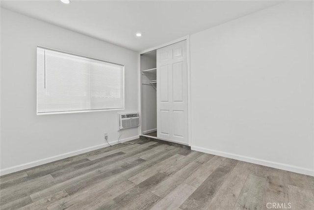 142 S Savannah St, Los Angeles, CA 90033 - unfurnished bedroom with wood finished floors, baseboards, recessed lighting, a closet, and an AC wall unit
