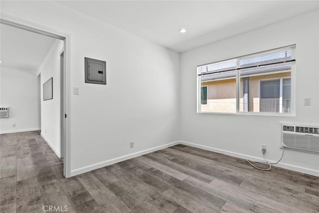 142 S Savannah St, Los Angeles, CA 90033 - unfurnished room featuring wood finished floors, a wall unit AC, electric panel, baseboards, and recessed lighting