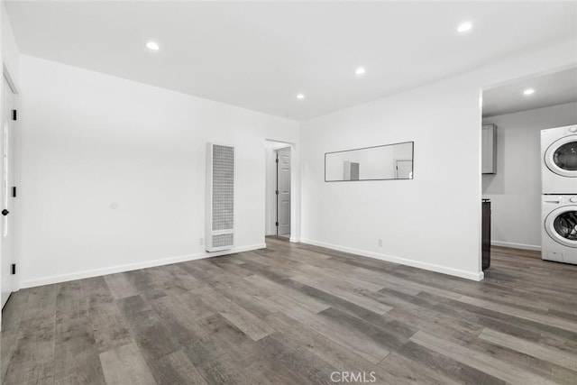 142 S Savannah St, Los Angeles, CA 90033 - unfurnished living room with a heating unit, stacked washing machine and dryer, recessed lighting, wood finished floors, and baseboards