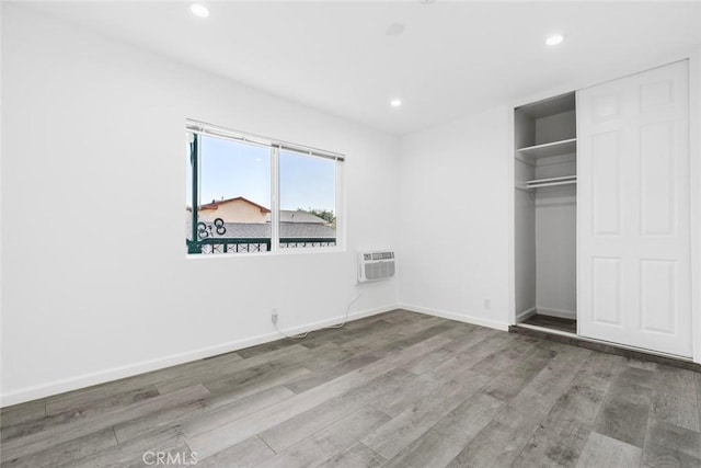 142 S Savannah St, Los Angeles, CA 90033 - unfurnished bedroom featuring wood finished floors, recessed lighting, a wall unit AC, baseboards, and a closet