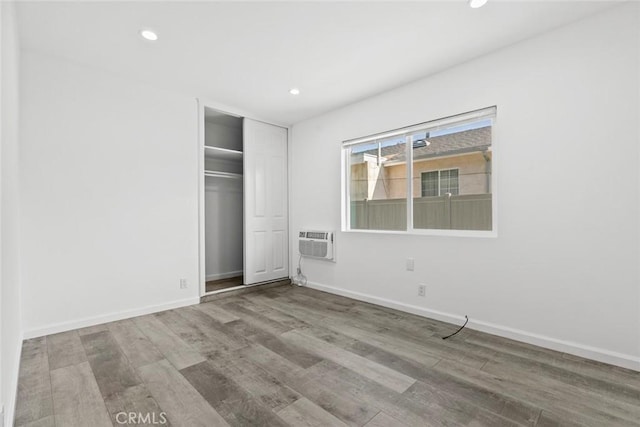 142 S Savannah St, Los Angeles, CA 90033 - unfurnished bedroom featuring recessed lighting, wood finished floors, baseboards, a wall mounted air conditioner, and a closet