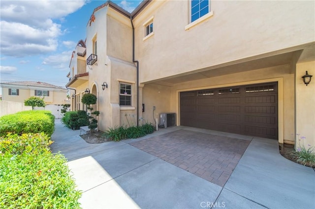 130 Alta St Unit B, Arcadia, CA 91006 - view of property exterior featuring stucco siding, an attached garage, driveway, and cooling unit