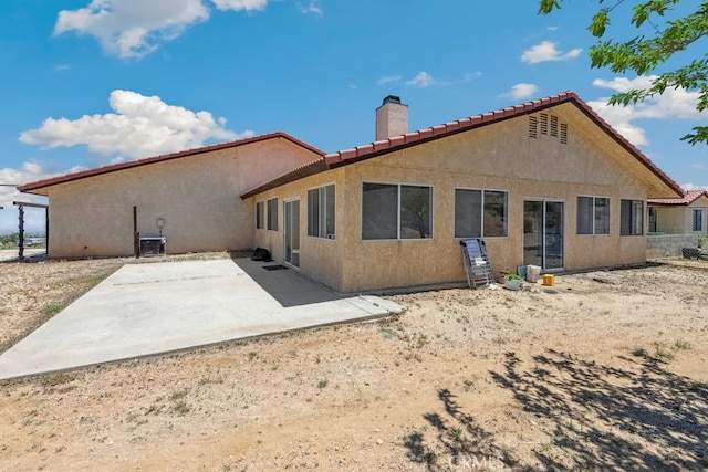 8636 Riggins Rd, Phelan, CA 92371 - back of house with a chimney, a tile roof, stucco siding, a patio area, and central AC