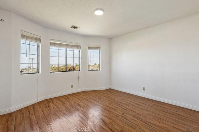 8636 Riggins Rd, Phelan, CA 92371 - spare room with wood finished floors, healthy amount of natural light, baseboards, and a textured ceiling