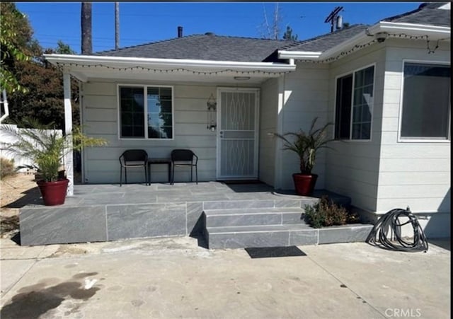 18763 Sunburst St, Northridge, CA 91324 - doorway to property featuring a shingled roof and a patio