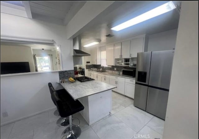 18763 Sunburst St, Northridge, CA 91324 - kitchen featuring stainless steel fridge, wall chimney exhaust hood, white cabinetry, a peninsula, and light countertops