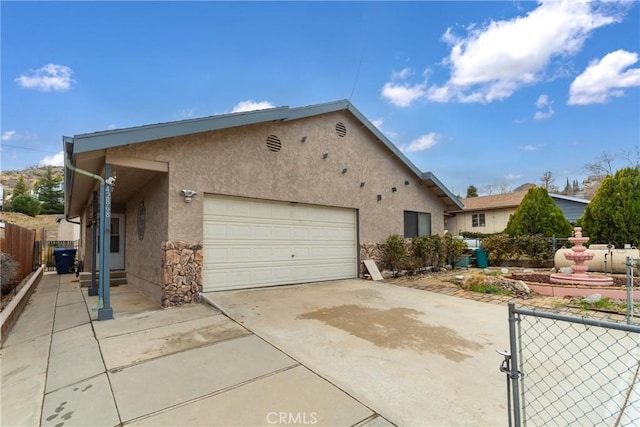 42868 Ranch Club Rd, Lake Elizabeth, CA 93532 - view of front of home with stucco siding, an attached garage, driveway, and a gate