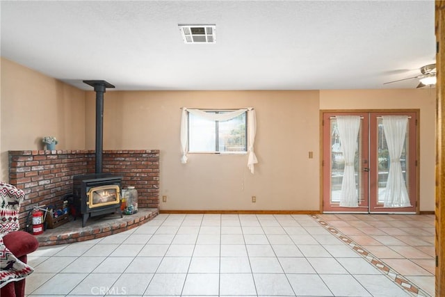42868 Ranch Club Rd, Lake Elizabeth, CA 93532 - unfurnished living room with a wood stove, light tile patterned floors, baseboards, and a ceiling fan