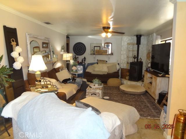 5475 Wilkinson Ave, Clearlake, CA 95422 - living room with a wood stove, a ceiling fan, and ornamental molding