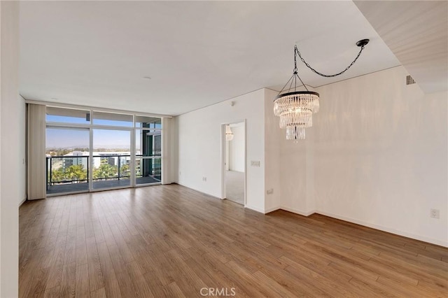 13650 Marina Pointe Dr Unit 908, Marina Del Rey, CA 90292 - unfurnished room featuring floor to ceiling windows, a chandelier, wood finished floors, and baseboards