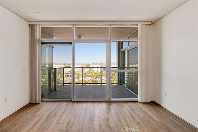 13650 Marina Pointe Dr Unit 908, Marina Del Rey, CA 90292 - unfurnished room with a wall of windows, plenty of natural light, wood finished floors, and baseboards