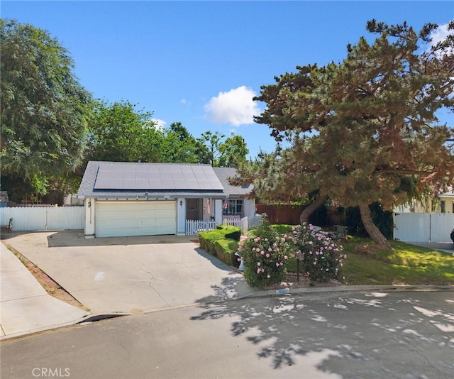 4060 Olive St, Chino, CA 91710 - view of front of property featuring roof mounted solar panels, a garage, and concrete driveway