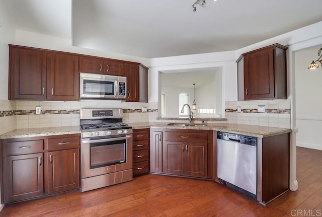 2407 Eastridge Loop, Chula Vista, CA 91915 - kitchen featuring stainless steel appliances, backsplash, dark wood-style floors, a sink, and light stone counters