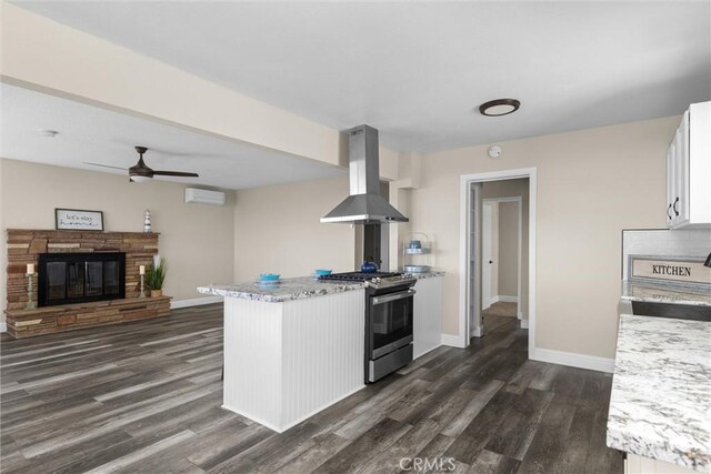 833 Park Ave, Cayucos, CA 93430 - kitchen featuring gas range, island exhaust hood, a peninsula, white cabinets, and dark wood-style flooring