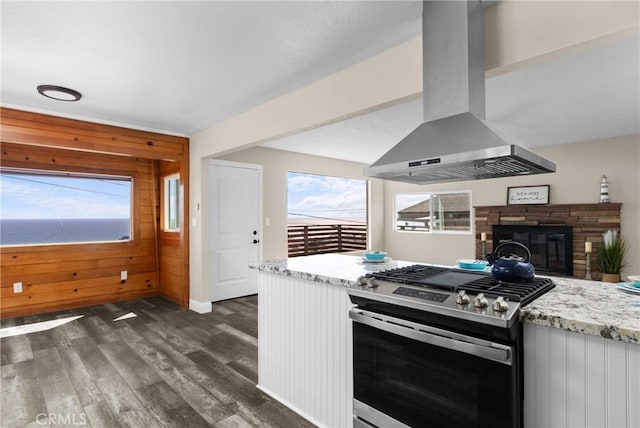 833 Park Ave, Cayucos, CA 93430 - kitchen with island exhaust hood, stainless steel gas range, dark wood-style flooring, healthy amount of natural light, and wooden walls