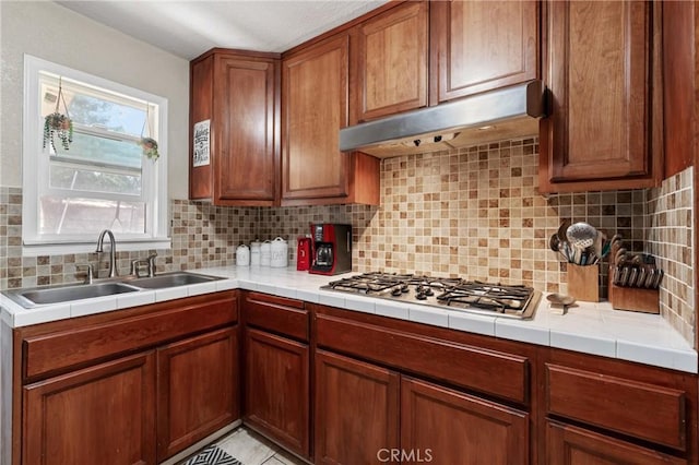 3970 Oakland Ave, Clearlake, CA 95422 - kitchen featuring stainless steel gas cooktop, under cabinet range hood, backsplash, and brown cabinetry