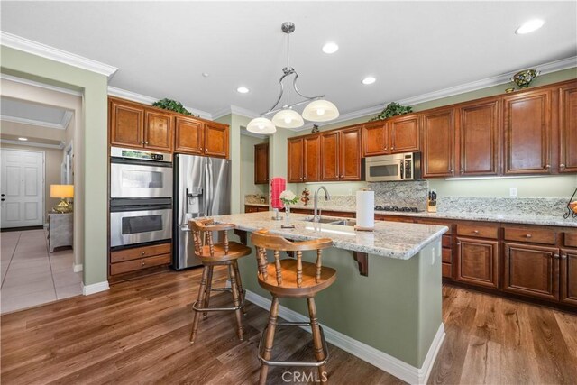 1625 Valley Falls Ave, Redlands, CA 92374 - kitchen featuring appliances with stainless steel finishes, crown molding, a kitchen island with sink, dark wood finished floors, and recessed lighting