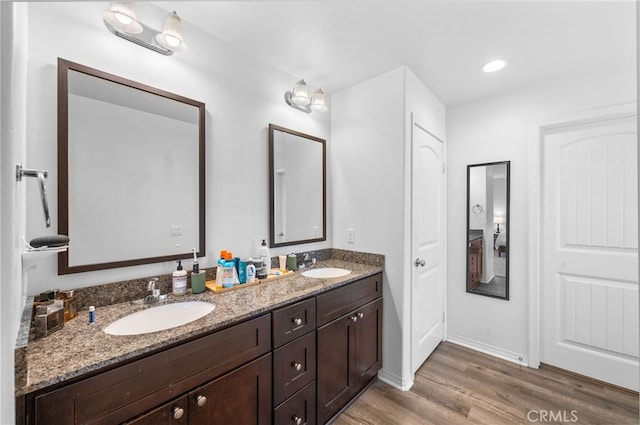 5609 Garibaldi Way, Fontana, CA 92336 - bathroom featuring wood finished floors, double vanity, and baseboards