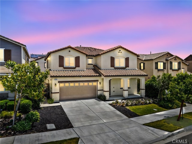 5609 Garibaldi Way, Fontana, CA 92336 - mediterranean / spanish home featuring a porch, a tile roof, stucco siding, concrete driveway, and an attached garage