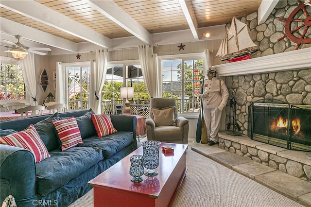 27888 W Shore Rd, Lake Arrowhead, CA 92352 - carpeted living room featuring a stone fireplace, plenty of natural light, wood ceiling with exposed beams, and a ceiling fan