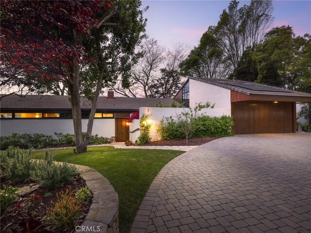 7 Cinchring Rd, Rolling Hills, CA 90274 - view of front of home featuring a chimney, a yard, decorative driveway, and stucco siding