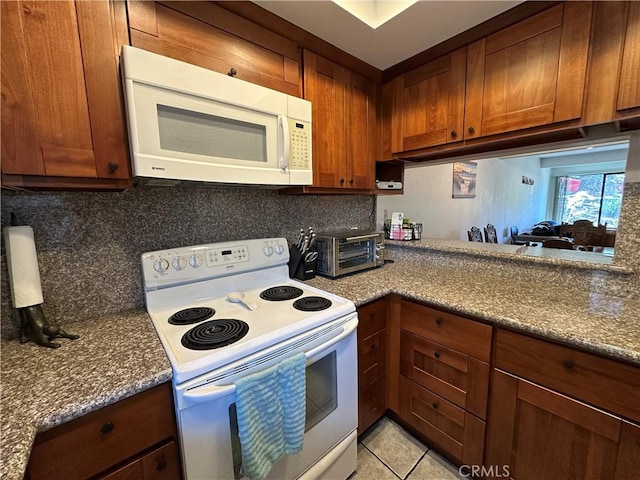 680 Chorro St Unit 18, San Luis Obispo, CA 93401 - kitchen with white appliances, tasteful backsplash, brown cabinets, dark stone counters, and light tile patterned flooring