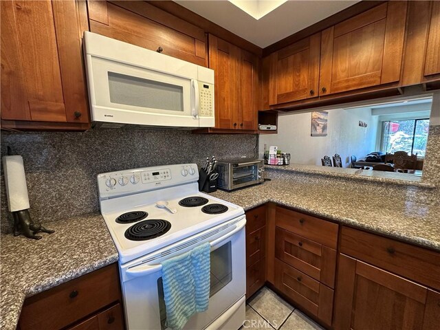 680 Chorro St Unit 18, San Luis Obispo, CA 93401 - kitchen with white appliances, backsplash, light tile patterned flooring, brown cabinetry, and dark stone counters